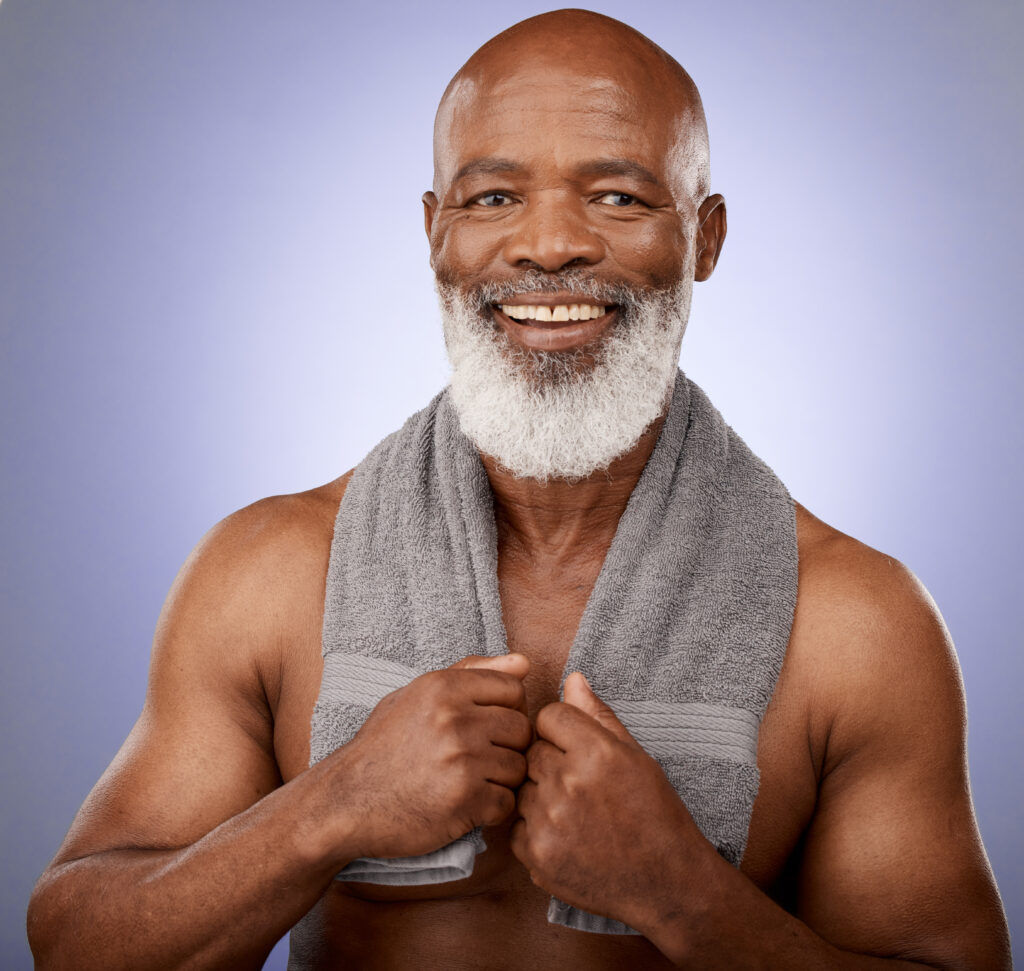 A man with white beard and no shirt holding onto his towel.